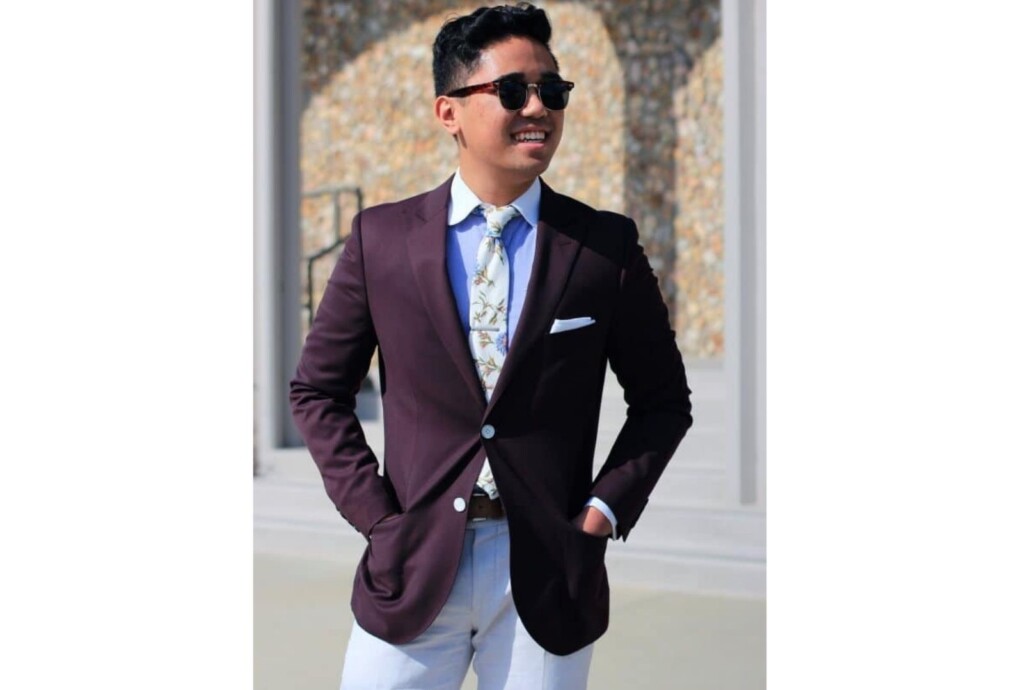 Ethan Wong pulling off a maroon blazer in the summer by combining it with distinctly warm weather elements, such as white and floral