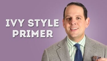 Rahale wearing agray suit, green and white striped dress shirt and navy blue knit tie