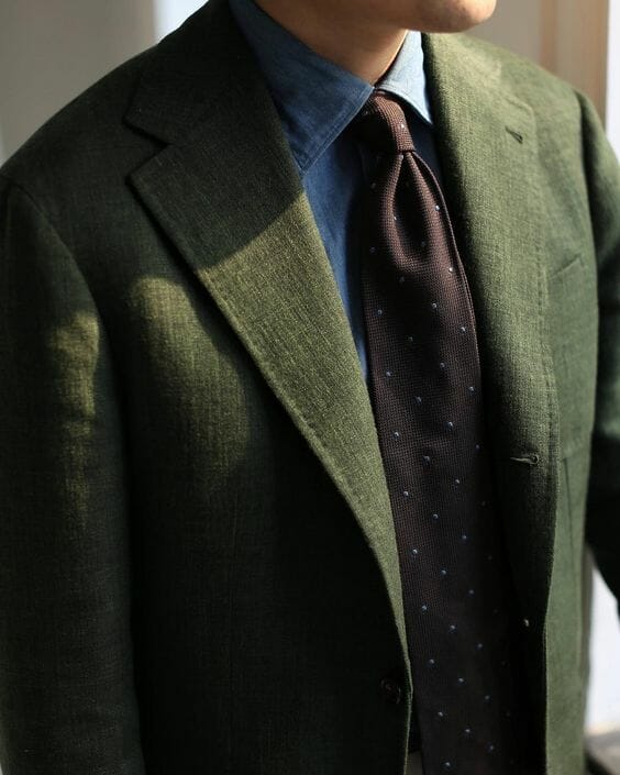 Denim shirt with green jacket and brown tie