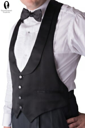 This black-tie waistcoat is a backless model, and features four polished buttons, a matte wool body with self-faced lapels, and two jetted pockets.