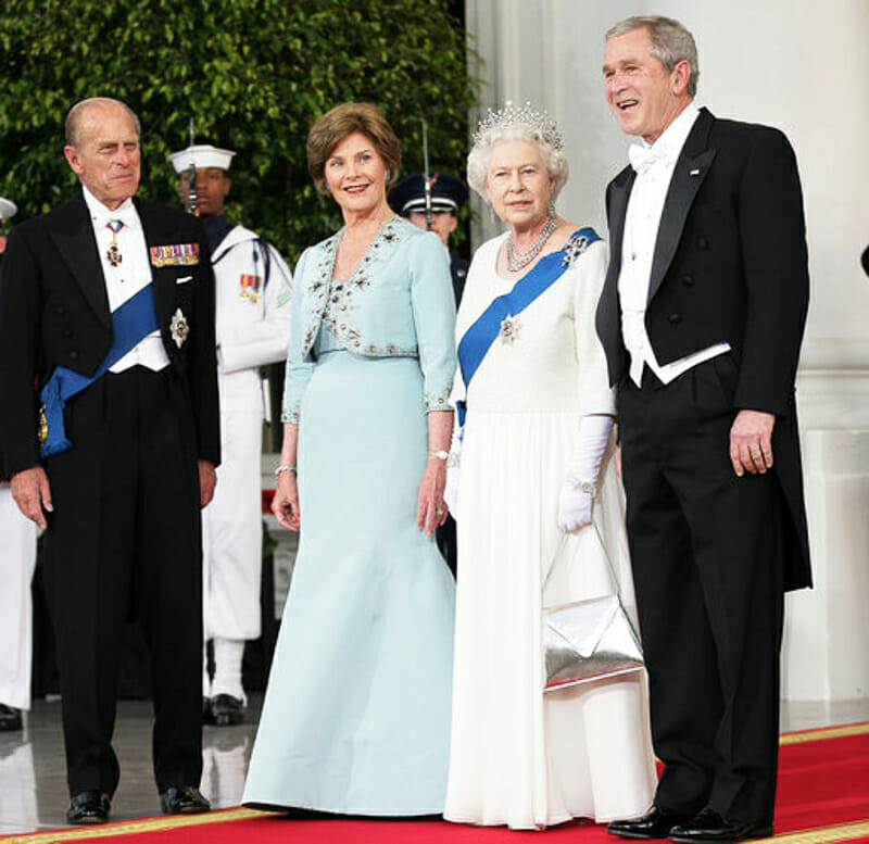 George Bush wearing a pathetic white tie ensemble  with the Queen