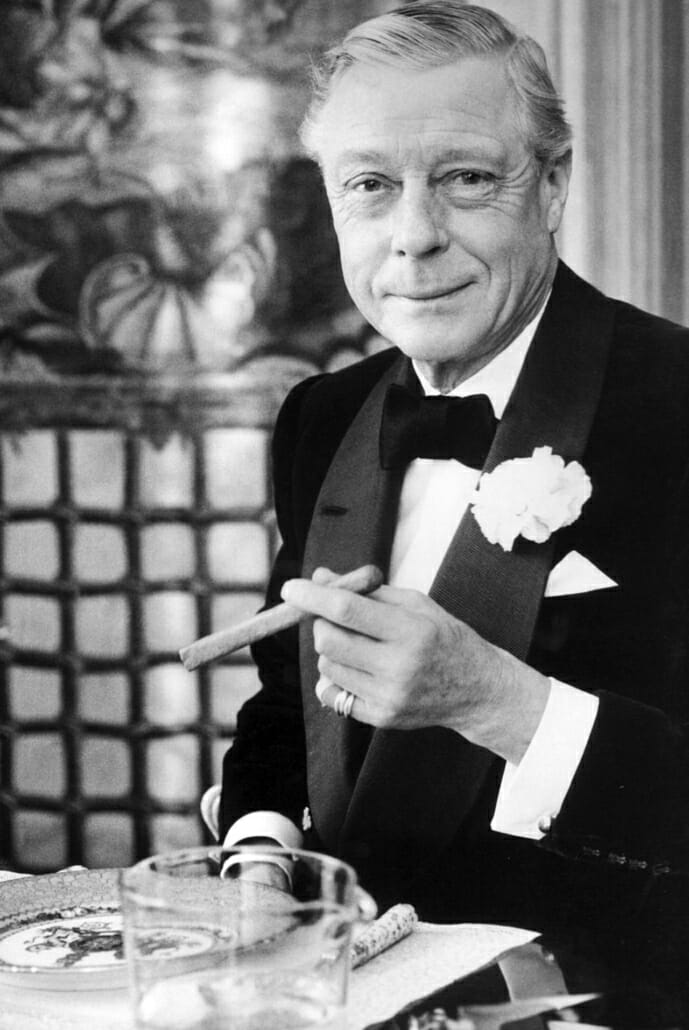 Edward populairzed the soft turndown collar for black tie. here he wearsshawl collar dinner jacket with grosgrain silk facing, carnation boutonniere, and loosely tied black bow tie