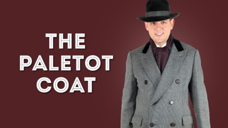 Raphael wearing gray paletot coat, ascot and black fedora hat