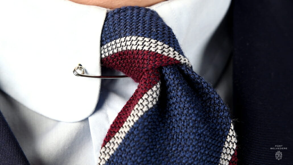 Close up of a wool cashmere grenadine tie in blue, burgundy red and white by Fort Belvedere