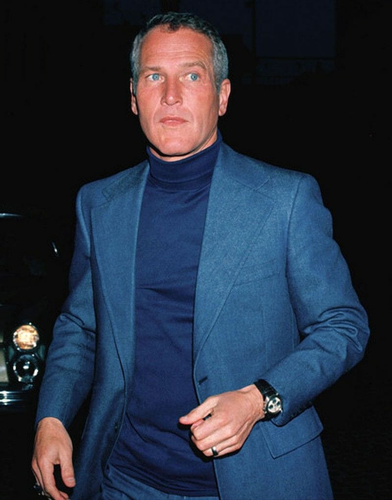 Paul Newman in a blue turtleneck and suit.