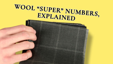 Preston pages through a "book" of wool suiting fabric samples; text reads, "Wool 'Super' Numbers, Explained"