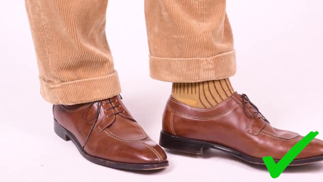 The trouser hem should just touch the shoe or show minimal break.