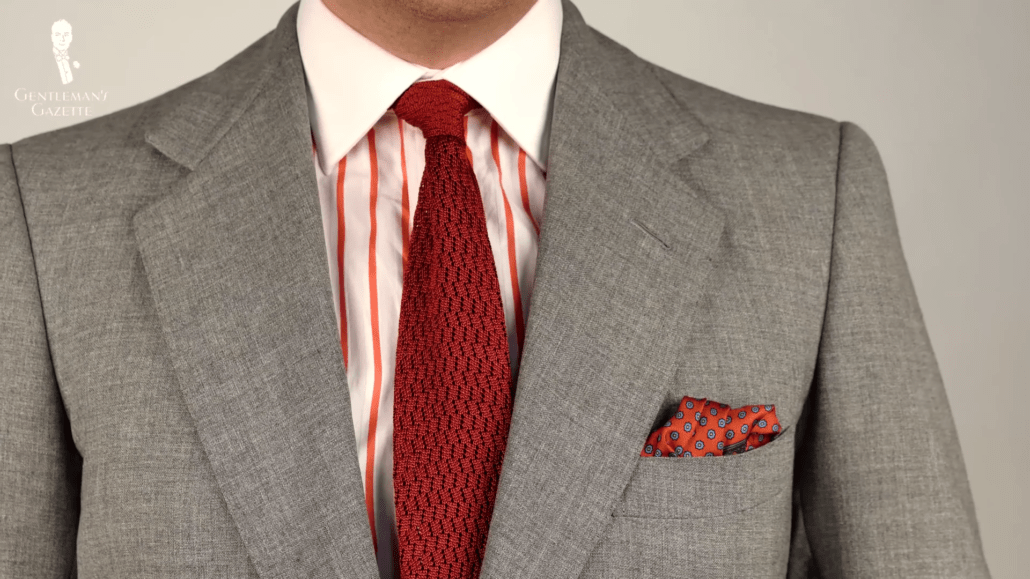 A textured tie in burnt orange is a natural complement to a white shirt with orange stripes.