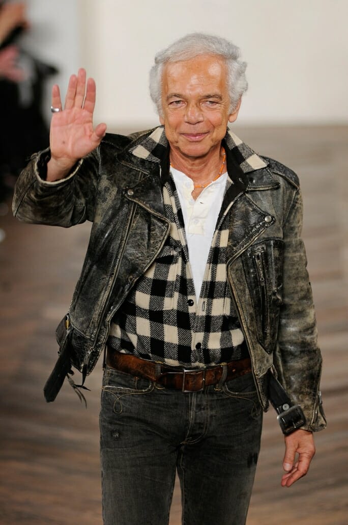 Ralph Lauren waving on the catwalk in a leather jacket and jeans