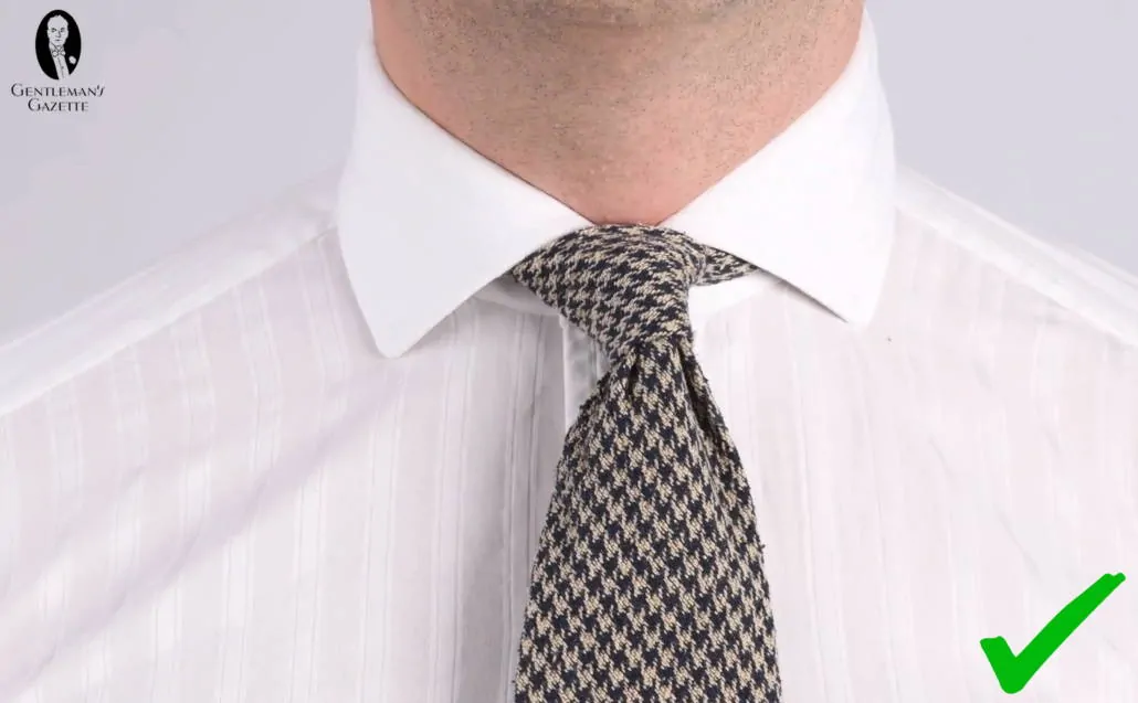 A four-in-hand knot can work with a spread collar if the tie is thicker and bulkier. (Pictured: Houndstooth Bourette Silk Tie in Navy Blue and Beige - Fort Belvedere)