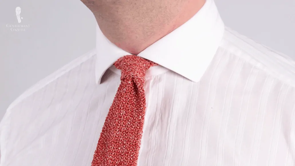 A four-in-hand tie knot, shown here with the Orange Red Mottled Knit Tie Cri De La Soie Silk from Fort Belvedere