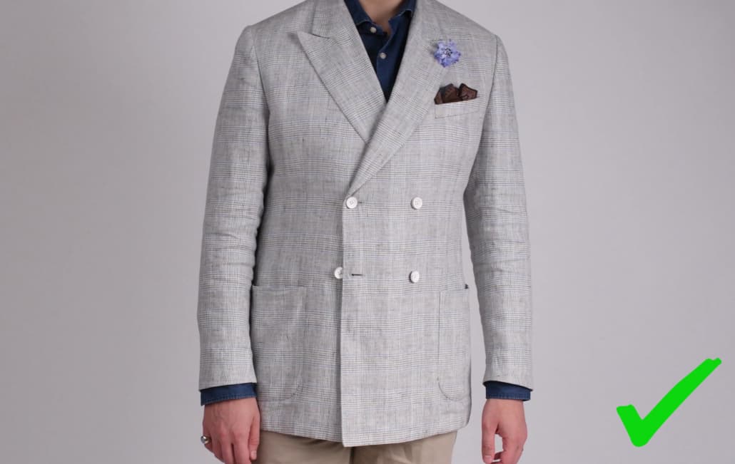 Raphael wearing a glen check double-breasted jacket combined with a Brown with Blue Paisley pocket square and Blue Cornflower Boutonniere from Fort Belvedere