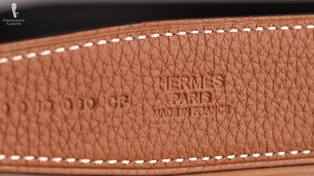 The detailed embossing on the leather strap of an Hermes belt.