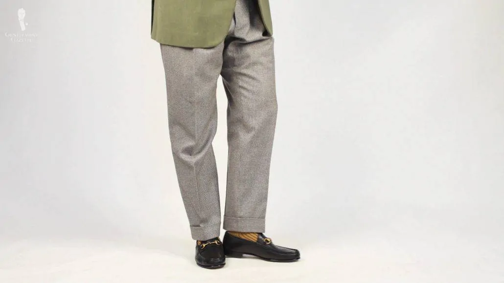 This pair of gray trousers features wider legs than current styles, but is flattering for Raphael's build. (Pictured: Caramel and Dark Burgundy Shadow Stripe Ribbed Socks from Fort Belvedere)