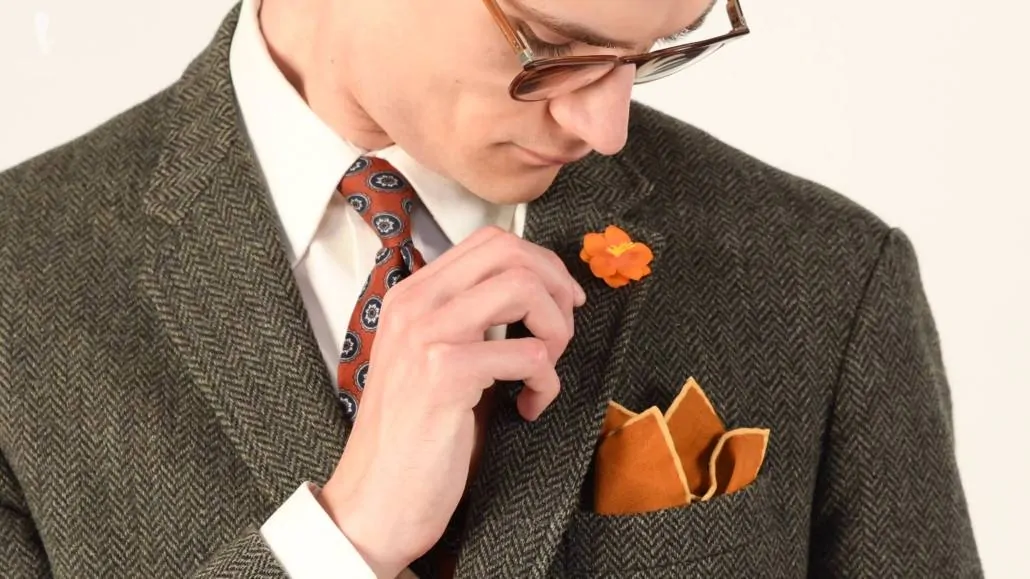 If your tie is heavily patterned, you can opt for a solid pocket square and just match its color with your boutonniere.