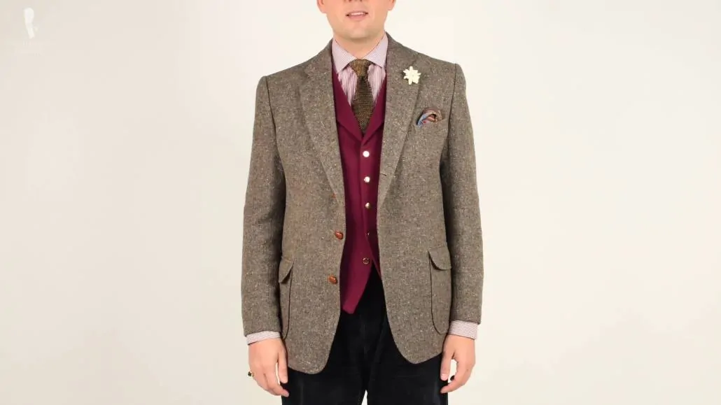 a-brown-Donegal-tweed-coat-with-a-burgundy-waistcoat-a-red-and-white-striped-shirt-and-a-cognac-peach-yellow-two-tone-knit-tie-scaled