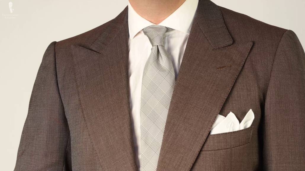 Brown patterned suit with a gray tie. 