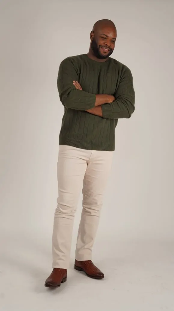Kyle; as 30s, wearing green cable knit sweater paired with cream colored jeans and leather weave brown boot.