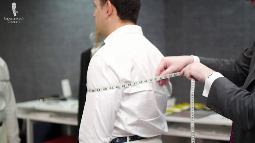 Raphael being measured for a bespoke shirt