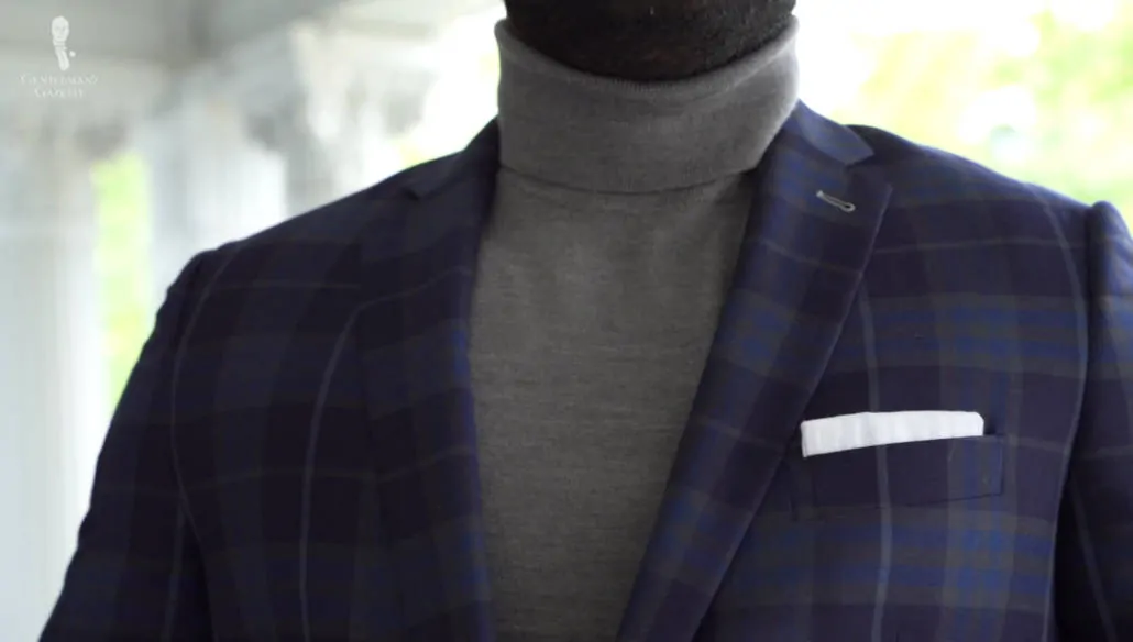 Checked sport coat and a gray turtleneck sweater with white linen pocket square from Fort Belvedere