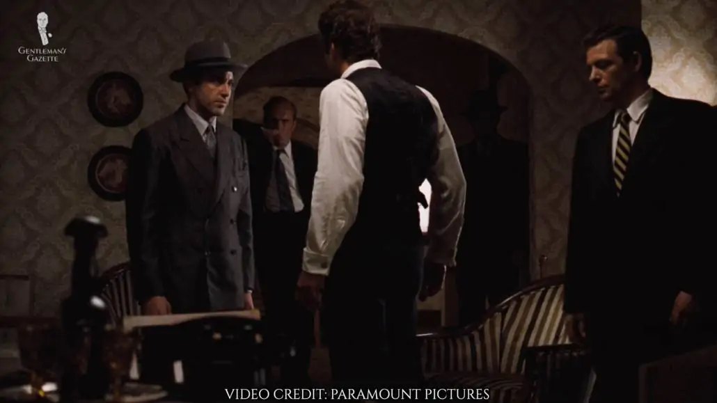 Michael Corleone wearing a gray double-breasted suit and a Homburg hat.