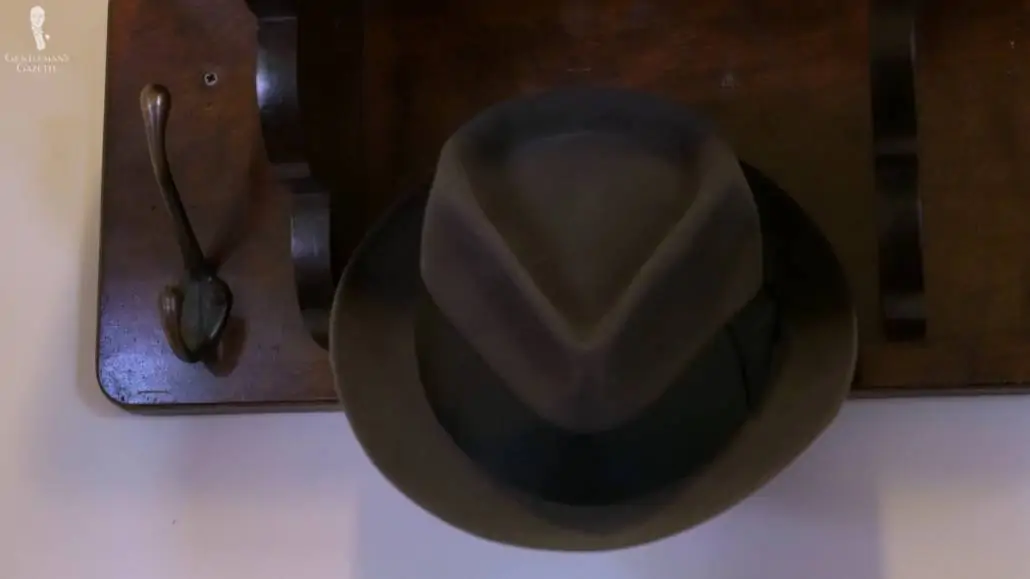Brown Fedora stored in a hat hook.