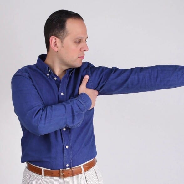 Raphael wearing a blue Eton dress shirt and stretching his arms.