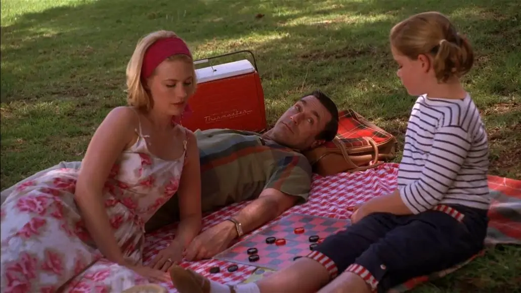 Don Draper having a picnic with his family. He's wearing a patterned sport shirt with a flared collar.