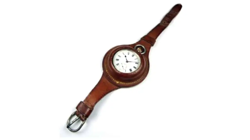 A wristlet with a leather strap and a pocket watch inside it
