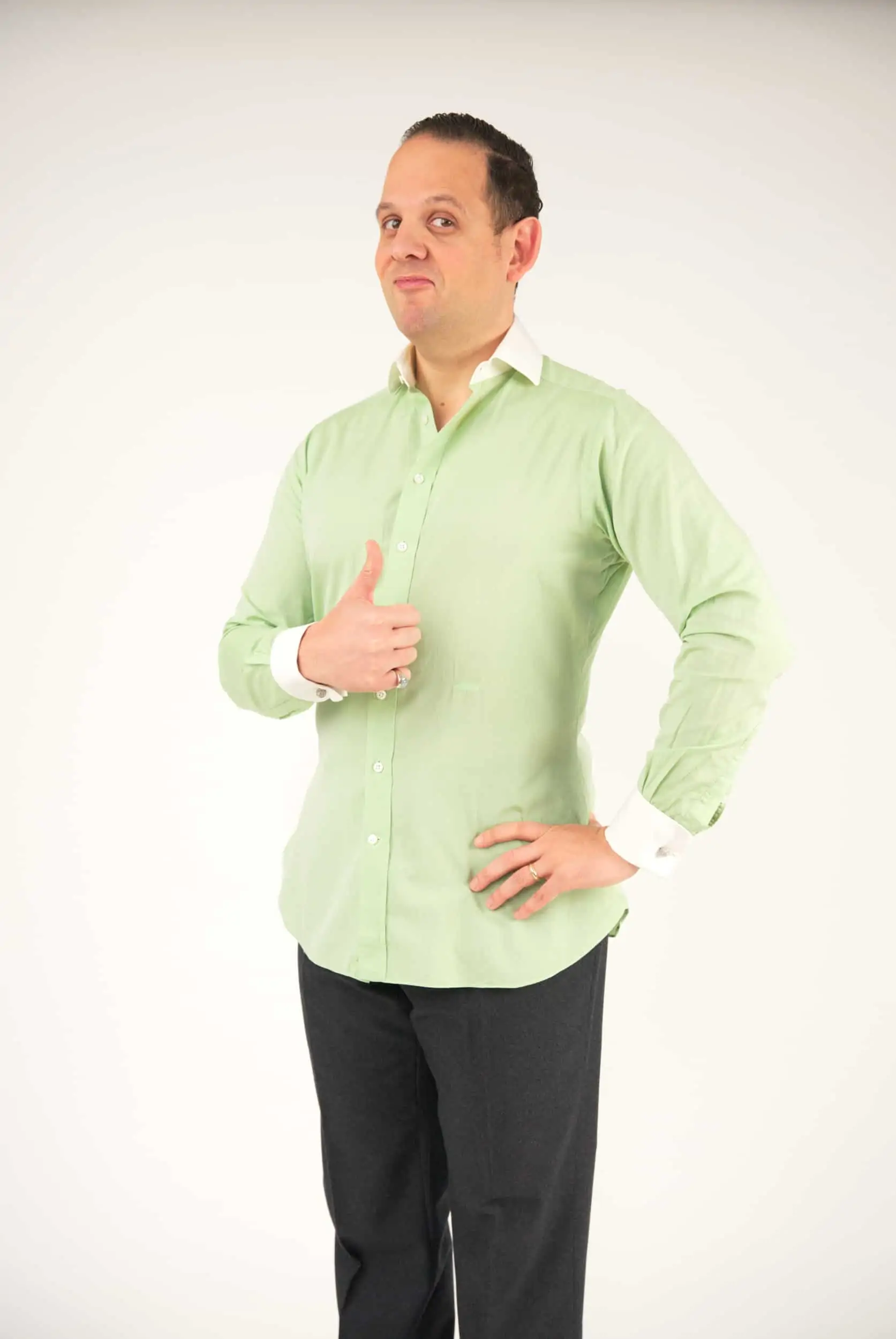 Raphael giving a thumbs up for his outfit; he's wearing a light green bespoke shirt With white French cuffs and spread collars.