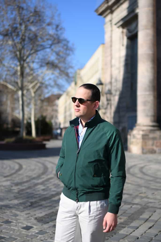 Raphael wearing a green G9 Harrington Jacket Baracuta, white chinos, and sunglasses.