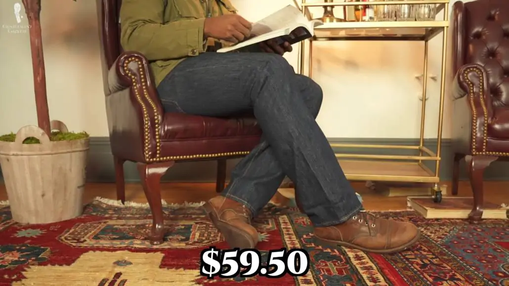 Image of Kyle's lower body showcasing the 501 jeans and his Red Wing Boots while reading a magazine. The price of the jeans is also captioned in the photo.