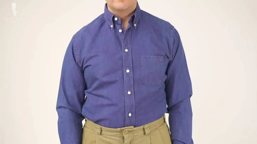 Raphael standing in a more relaxed manner; he's wearing a blue denim shirt and khaki chinos