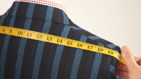 Shoulder measurement on a striped patterned suit jacket on a mannequin