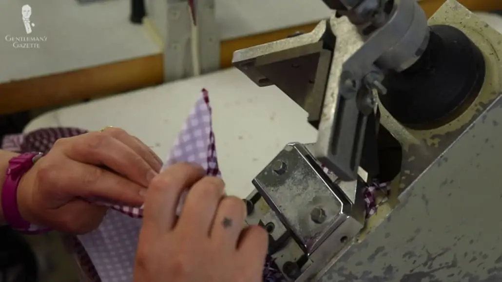 A shirt being sewn together using a machine. 