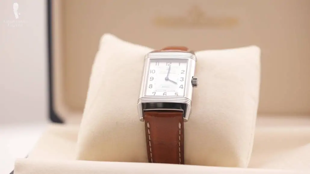 A Classic Reverso Watch with a brown leather strap in a watch cusion