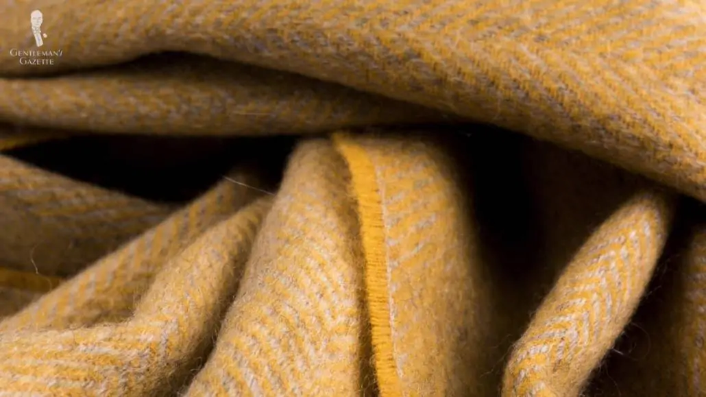 A close up of Herringbone Cashmere Scarf in Mustard Yellow and Grey - Fort Belvedere