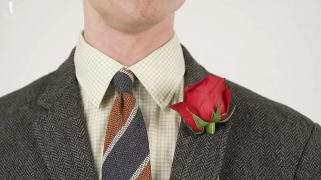 Preston wearing a natural rose boutonniere with it's bloom facing inward.