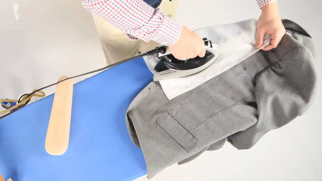Raphael using a pressing cloth to iron his sport coat