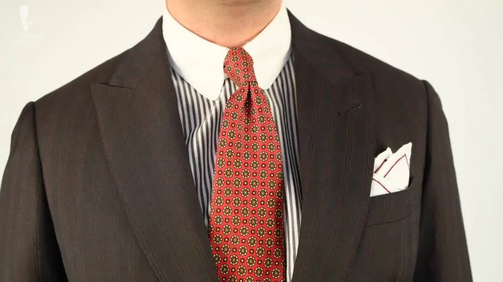 Brown patterned suit with blue striped Winchester shirt, orange tie, and white pocket square with white lining