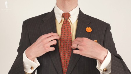 Brown patterned suit and yellow Winchester shirt, orange boutonniere, orange tie and cufflinks from Fort Belvedere
