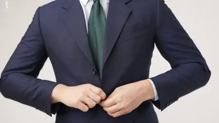 A navy suit with a green tie 