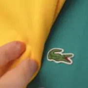 Two Lacoste polo shirts logos side by side. One appears larger than the other.