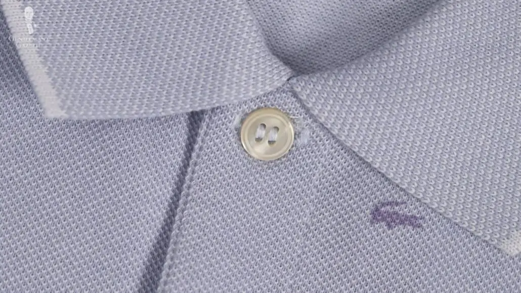 Plastic button on a Lacoste Paris polo shirt.