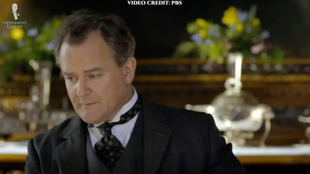 Lord Grantham wearing black suit and checked neckwear