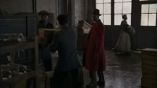 Chalky White wearing a red double-breasted overcoat, which is a rather bold choice.