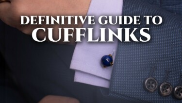 Definitive Guide to Cufflinks_1200x630 Raphael in a blue jacket and lilac French cuffed shirt, wearing Fort Belvedere Eagle Claw Cufflinks in Gold with blue lapis lazuli stones