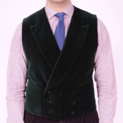 Raphael wearing a black double-breasted velvet vest, pink long-sleeved shirt, and blue knit tie