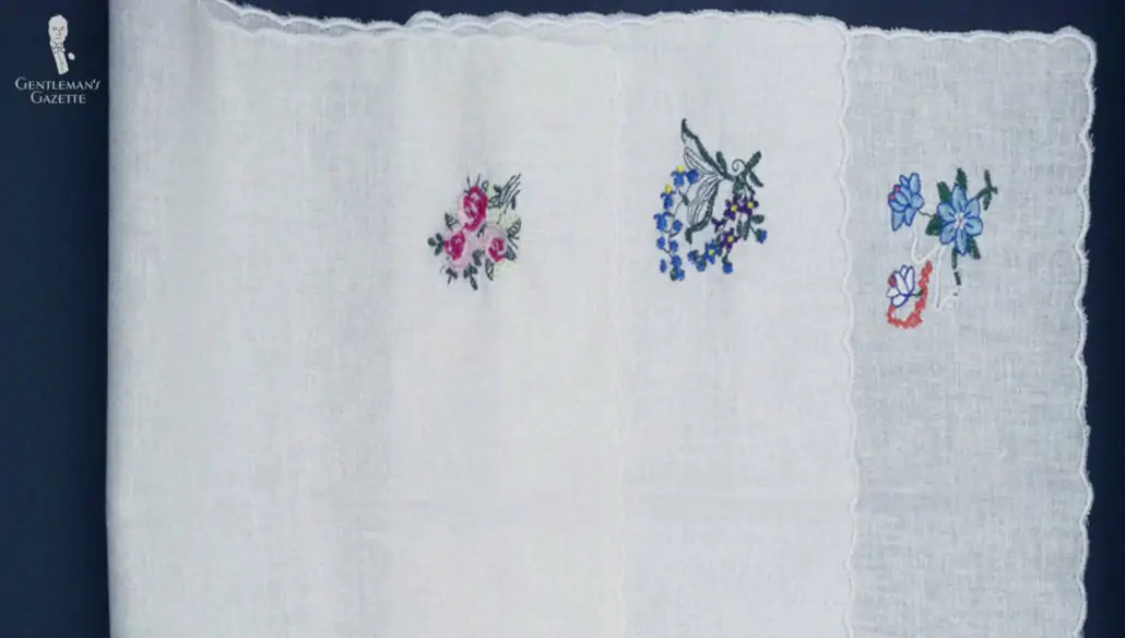 white pocket squares with embroidered image in the corner