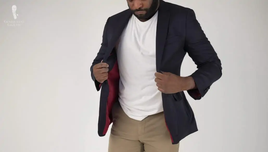 The modern gent look with a white t-shirt, light brown trousers, and navy jacket.